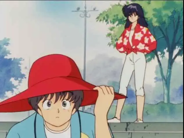 A boy in a red hat looking up at a girl in a red and white outfit standing on what appears to be a wall or ledge