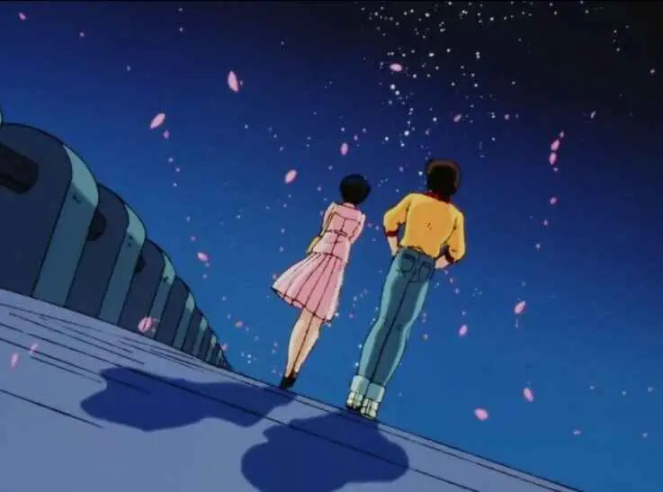 A young man and woman standing together under a starry night sky with cherry blossom petals falling