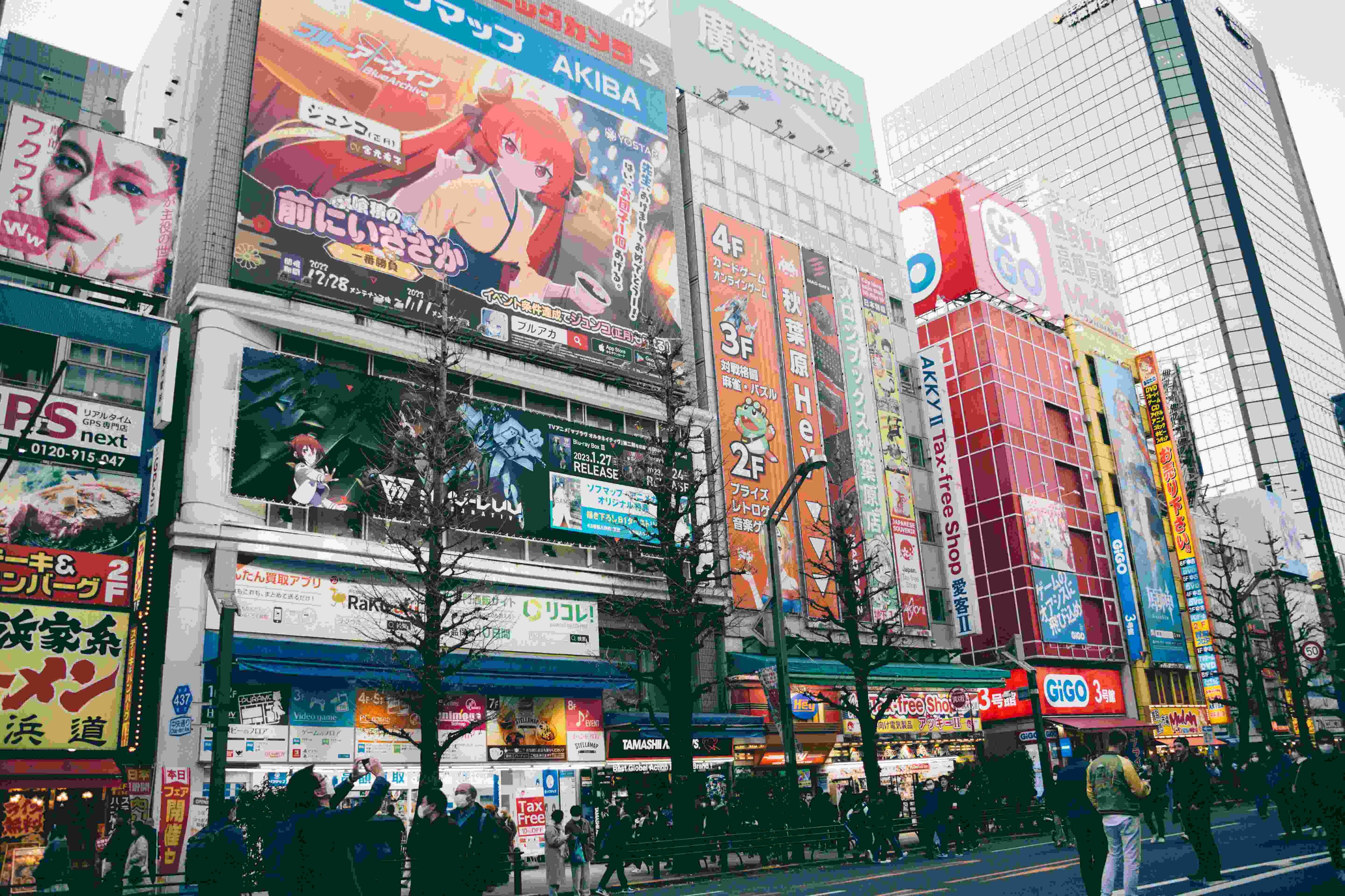 A bustling Japanese street filled with colorful anime posters, streaming ads, and character banners.
